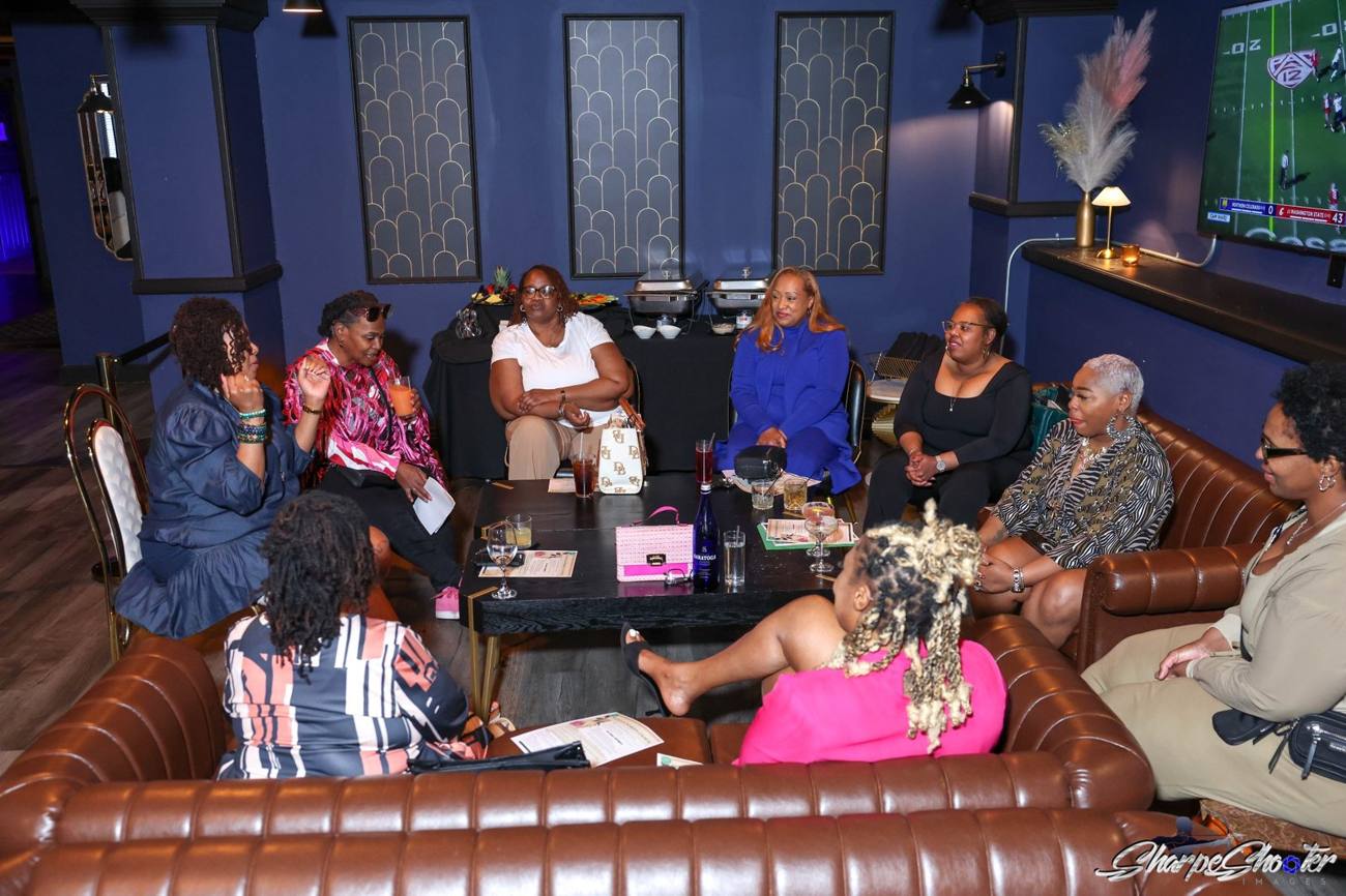 Women of The RARE Collective in conversation around a table
