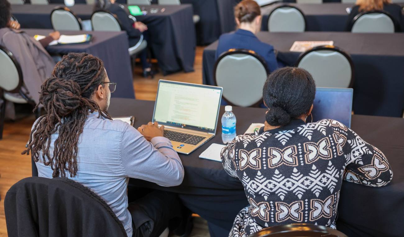 Two attendees working on laptops during a training session