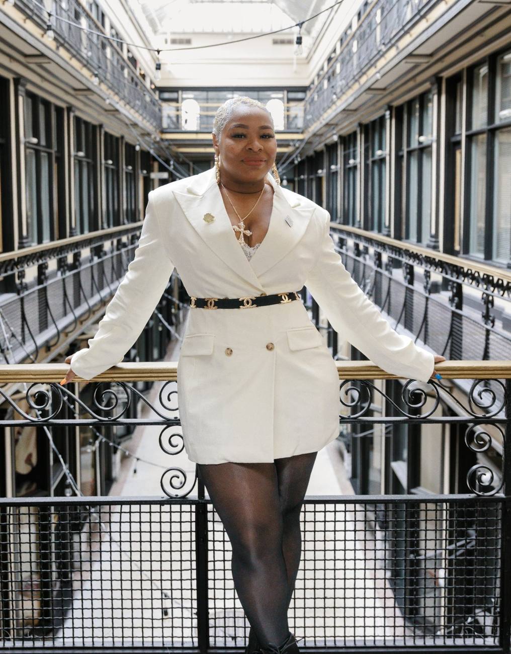 Talia Johnson Huff in a white blazer on a balcony inside a historic arcade