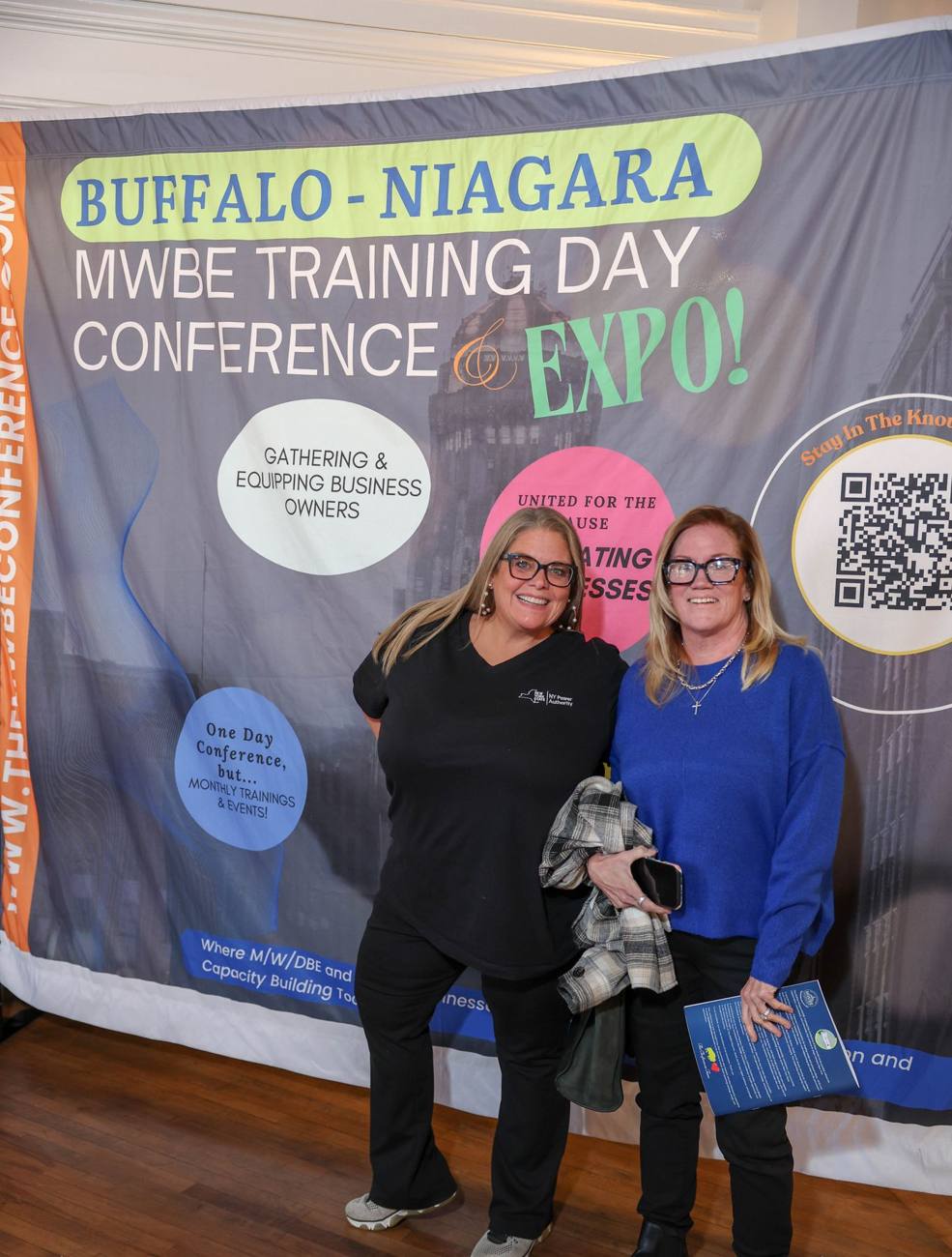 Two guests from the NY Power Authority at the conference backdrop